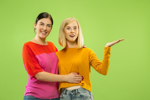 Retrato de chicas muy encantadoras en trajes casuales en estudio verde