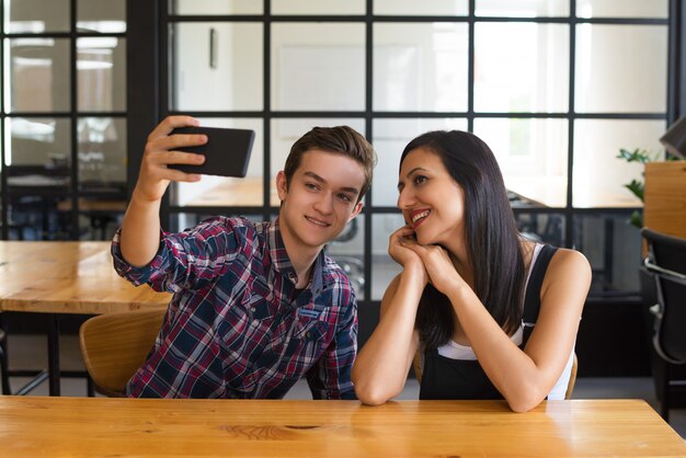 Retrato de chico feliz tomando selfie con su novia