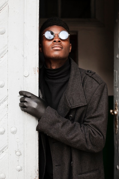 Retrato de chico guapo con gafas de sol y guantes