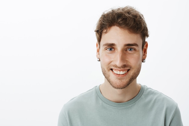 Retrato de un chico sonriente casual posando en el estudio