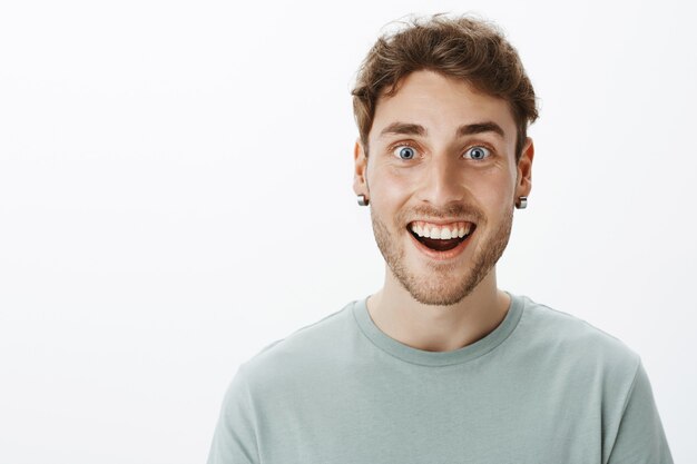 Retrato de un chico sonriente casual posando en el estudio