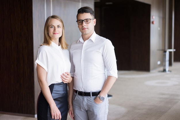 Retrato de colegas de negocios seguros posando en el edificio de oficinas.