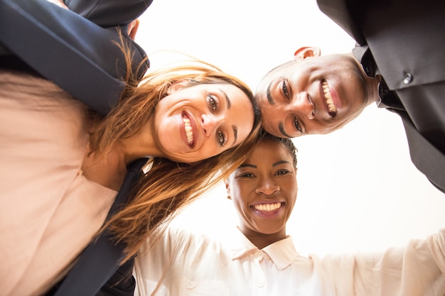 Foto gratuita retrato de colegas sonrientes abrazando y mirando a cámara