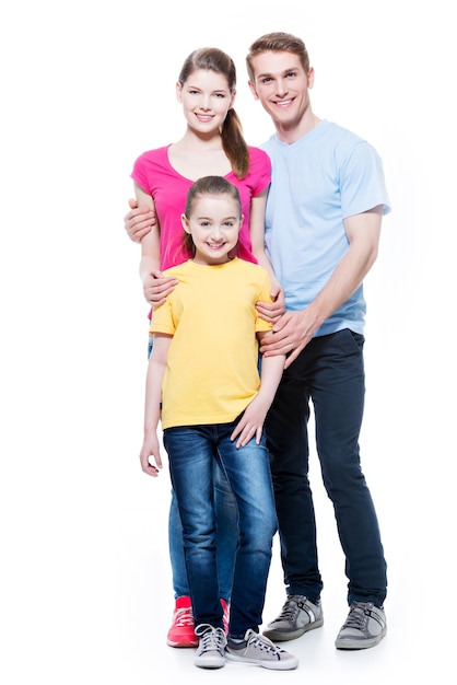 Retrato completo de la familia joven feliz con hija en camisetas multicolores - aislado en la pared blanca.