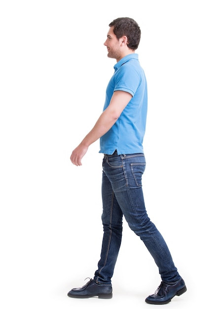 Retrato completo del hombre que camina sonriente en casuals de la camiseta roja - aislado en blanco.