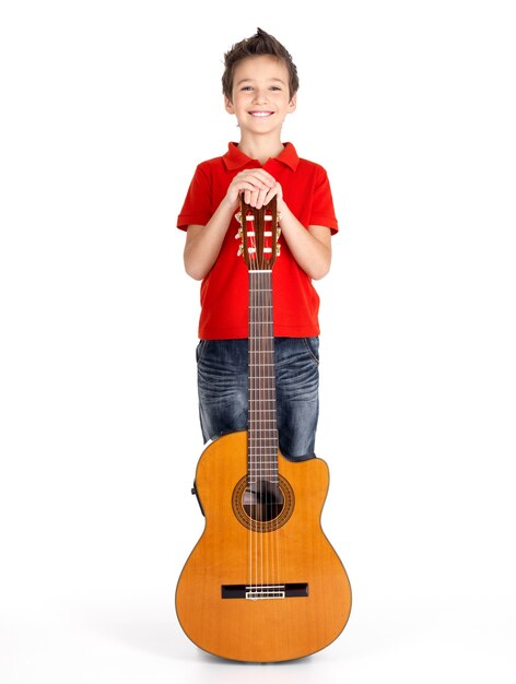 Retrato completo de niño caucásico con guitarra acústica -