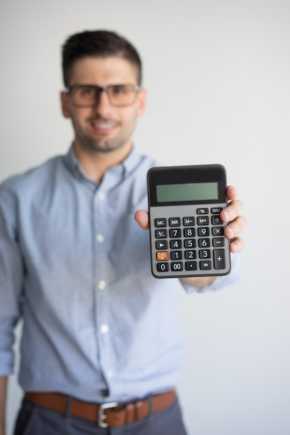 Retrato del contador feliz en los vidrios que muestran la calculadora.