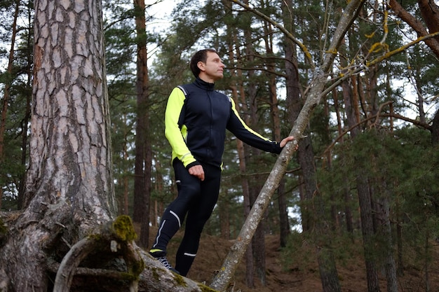 Retrato corporal completo de hombre deportivo en un bosque.