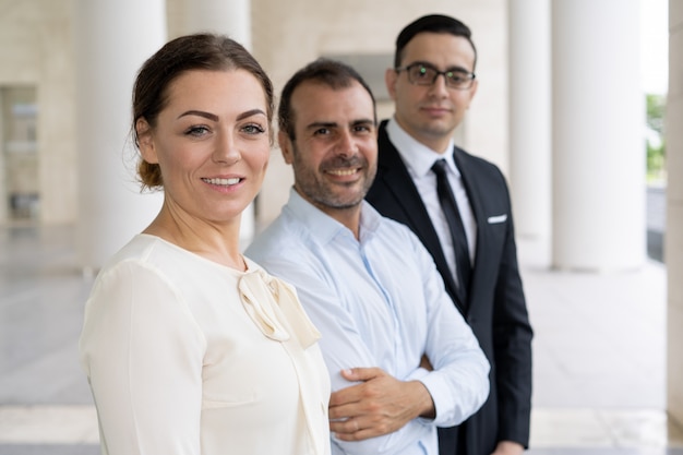 Retrato corporativo de la señora de negocios muy sonriente con compañero de trabajo