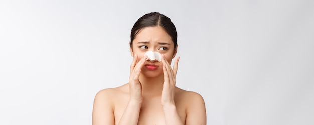 Retrato de cosmetología de hermosa modelo asiática femenina con máscara en la nariz Primer plano de mujer joven sana con piel suave pura y maquillaje natural fresco