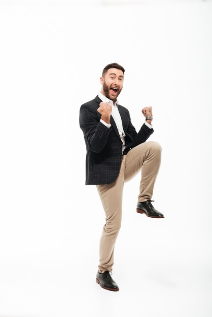 Retrato de cuerpo entero de un alegre hombre feliz celebrando el éxito