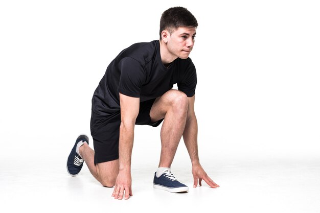 Retrato de cuerpo entero de un atleta masculino listo para correr aislado en blanco