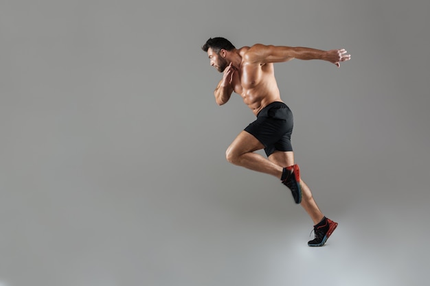 Retrato de cuerpo entero de un culturista masculino sin camisa en forma saludable