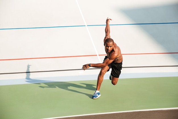 Retrato de cuerpo entero de un deportista motivado medio desnudo