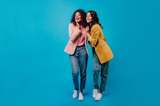 Retrato de cuerpo entero de dos mujeres disfrutando de la conversación