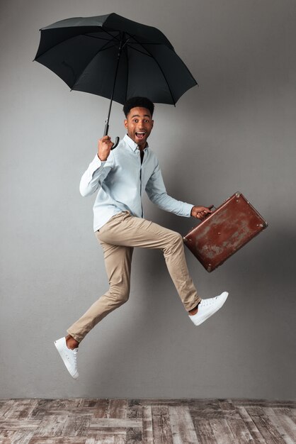 Retrato de cuerpo entero de un feliz alegre hombre africano saltando