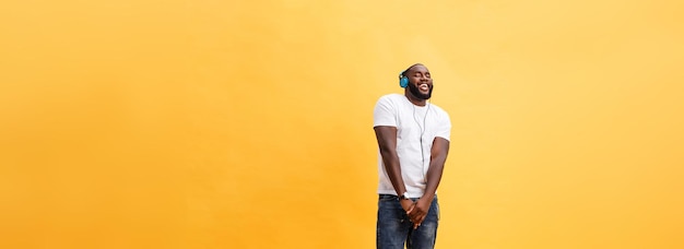 Retrato de cuerpo entero de un joven afroamericano cereza escuchando música con auriculares y d