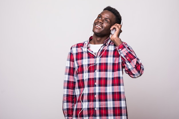 Retrato de cuerpo entero de un joven afroamericano escuchando música con auriculares aislados