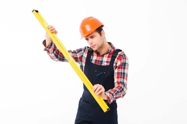 Retrato de cuerpo entero de un joven constructor masculino concentrado