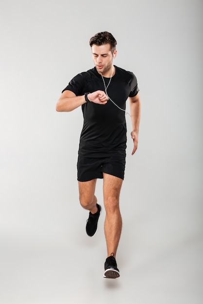 Retrato de cuerpo entero de un joven deportista en forma de auriculares