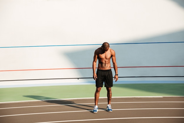 Retrato de cuerpo entero de un joven deportista musculoso