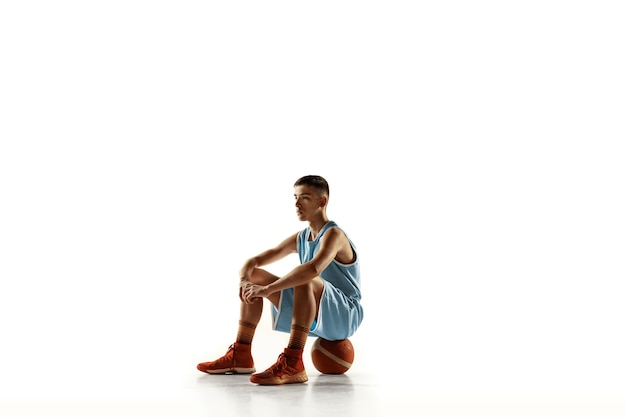 Retrato de cuerpo entero del joven jugador de baloncesto con una pelota aislada en el espacio en blanco