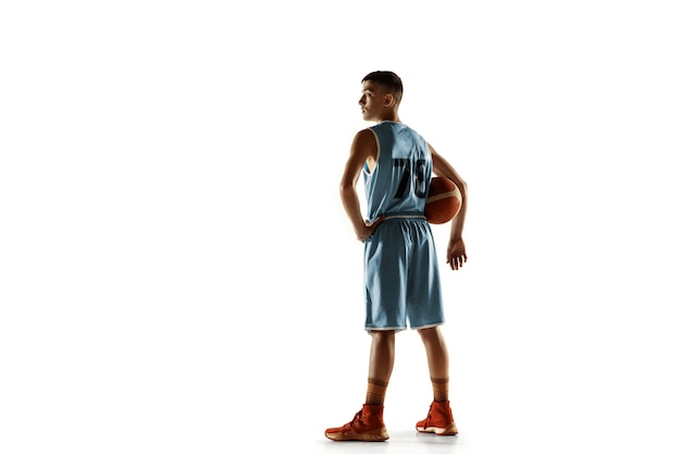 Retrato de cuerpo entero del joven jugador de baloncesto con una pelota aislada en el espacio en blanco