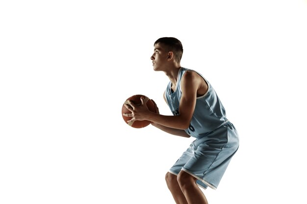 Retrato de cuerpo entero del joven jugador de baloncesto con una pelota aislada sobre fondo blanco de estudio. Adolescente entrenando y practicando en acción, movimiento. Concepto de deporte, movimiento, estilo de vida saludable, anuncio.