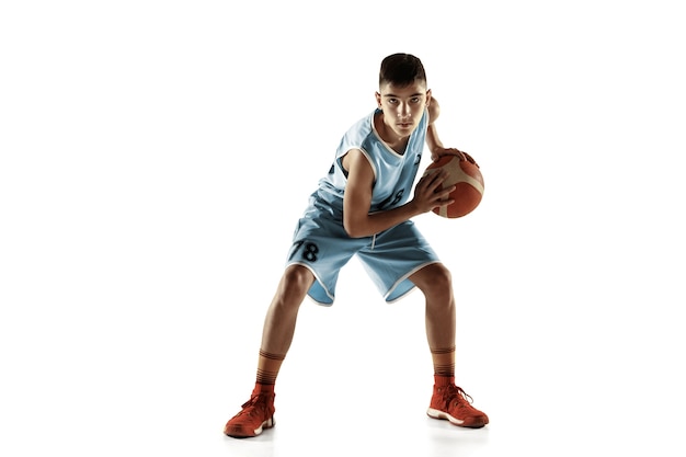 Retrato de cuerpo entero del joven jugador de baloncesto con una pelota aislada sobre fondo blanco de estudio. Adolescente entrenando y practicando en acción, movimiento. Concepto de deporte, movimiento, estilo de vida saludable, anuncio.