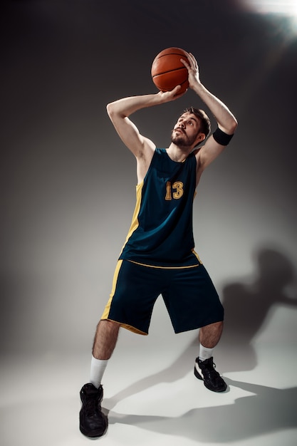 Retrato de cuerpo entero de un jugador de baloncesto con pelota