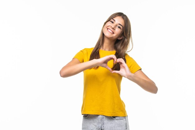 Retrato de cuerpo entero de una mujer joven y bonita haciendo un signo de corazón con sus manos