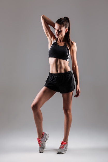 Retrato de cuerpo entero de una mujer joven concentrada fitness