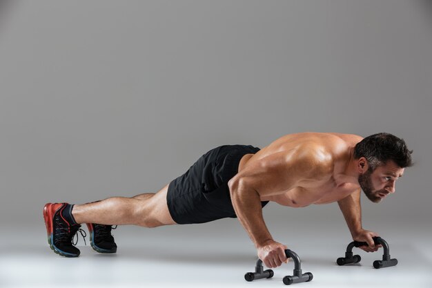 Retrato de cuerpo entero de un musculoso culturista masculino sin camisa fuerte