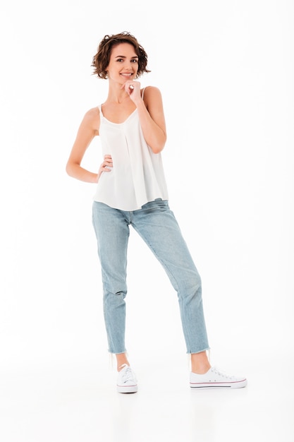 Retrato de cuerpo entero de una niña alegre sonriente posando