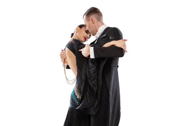 Retrato de cuerpo entero de una pareja joven practicando bailes de salón aislado sobre fondo blanco de estudio