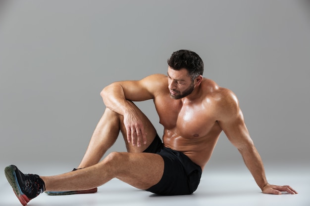 Retrato de un culturista masculino sin camisa fuerte cansado relajante