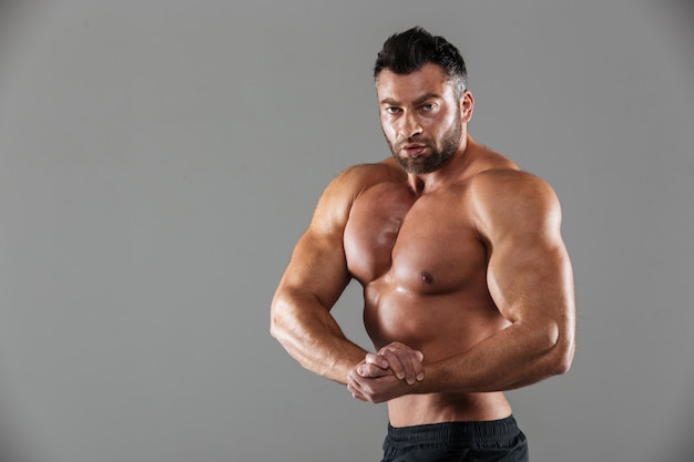 Retrato de un culturista masculino descamisado seguro muscular