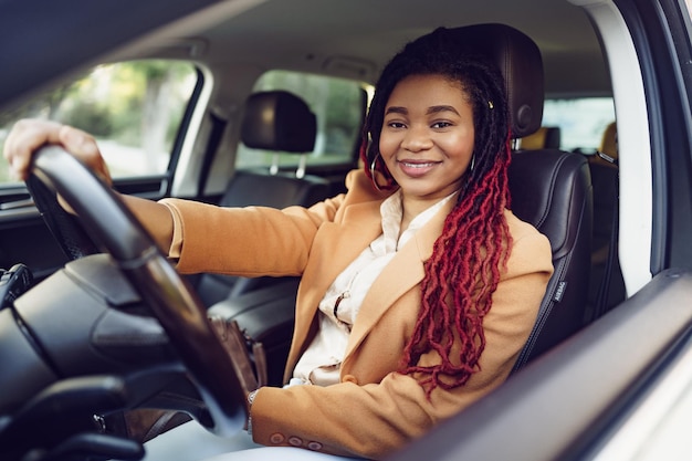 Retrato de dama afroamericana positiva dentro del coche