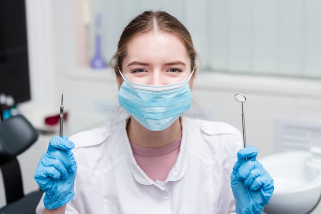 Retrato de dentista feliz con herramientas