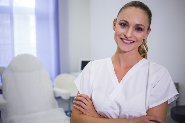 Foto gratuita retrato de dentista de pie con los brazos cruzados