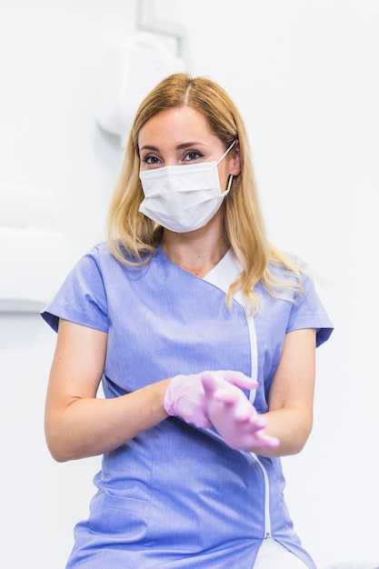 Retrato de un dentista de sexo femenino que lleva guantes rosados