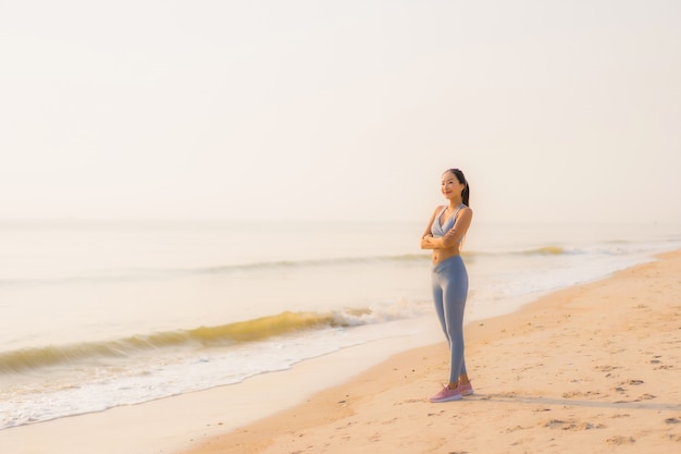 Retrato deporte joven mujer asiática preparar ejercicio o correr en la playa mar océano