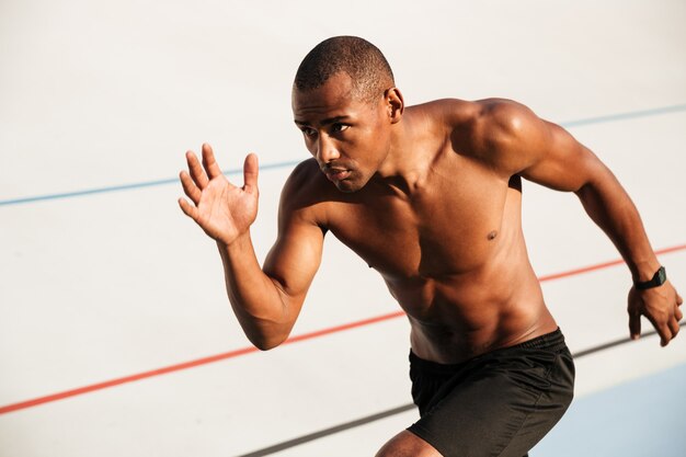 Retrato de un deportista musculoso medio desnudo corriendo