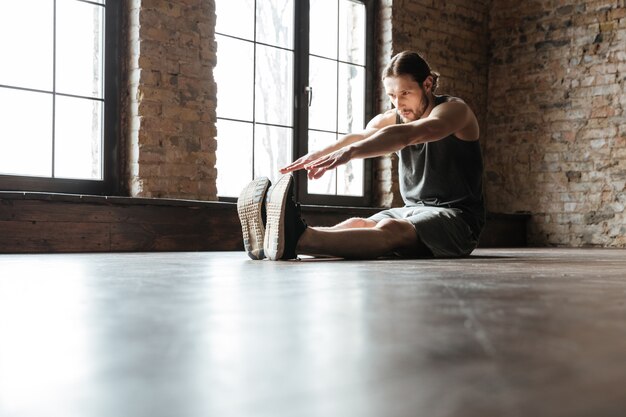 Retrato de un deportista sano haciendo ejercicios de estiramiento