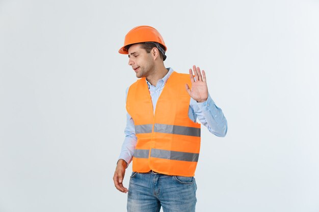Retrato de diseñador o arquitecto confundido, se siente estresado, nervioso, mantiene la mano en la cabeza, mira fijamente el plano. El hombre exhausto crea un proyecto de construcción solo, tiene algunos problemas.