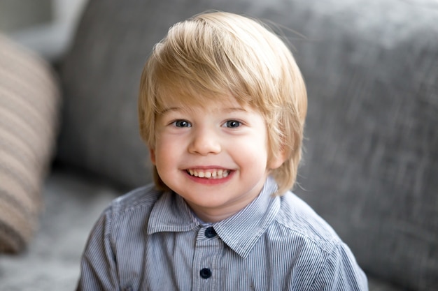 Foto gratuita retrato de disparo en la cabeza de un niño sonriente lindo mirando a la cámara