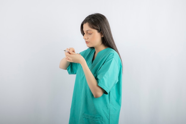 Retrato de doctora sosteniendo una jeringa grande. .