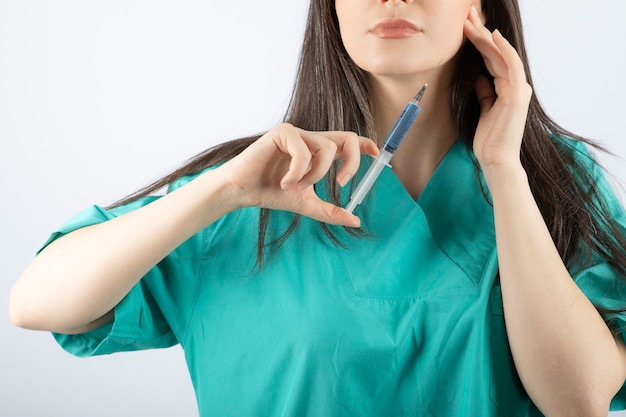 Retrato de doctora sosteniendo una jeringa grande. .