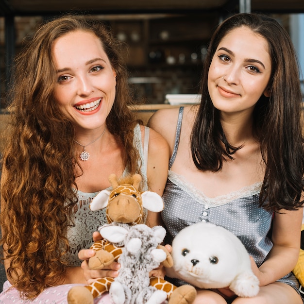 Foto gratuita retrato de dos amigas con peluche