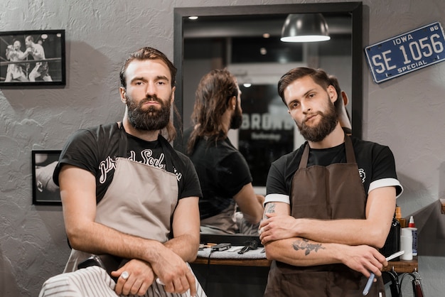 Retrato de dos barberos masculinos que miran la cámara